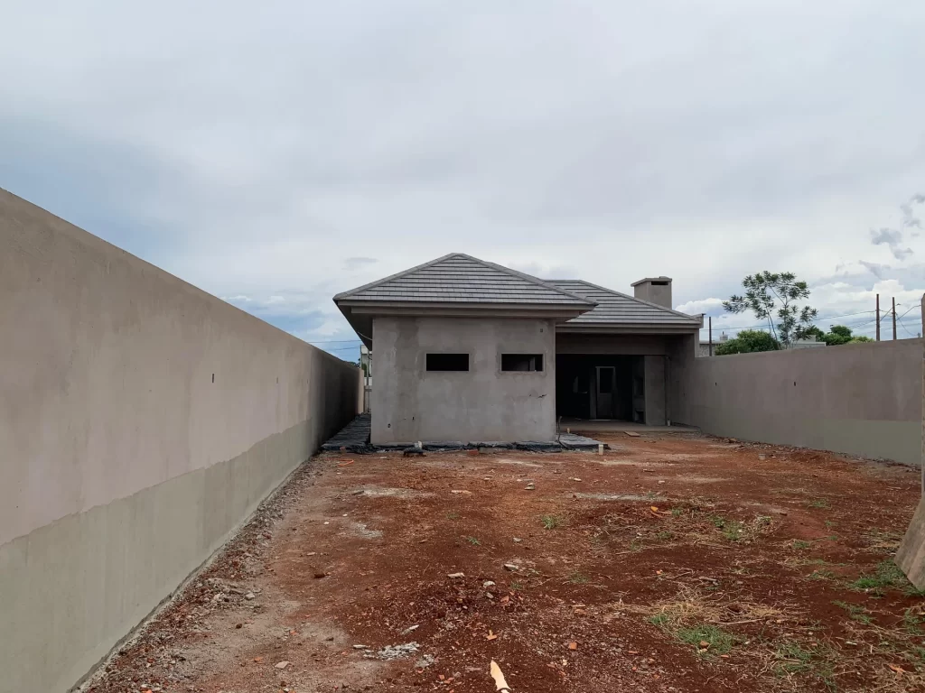 Residência térrea em fase de acabamento com telhado concluído e quintal em terra
