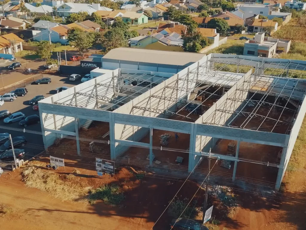 Vista aérea de prédio comercial em pré-moldado com estrutura metálica de cobertura na avenida
